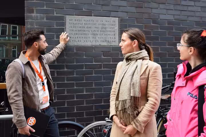 Guide explains Haarlem WWII memorial plaque on Corrie ten Boom World War II walking tour experience