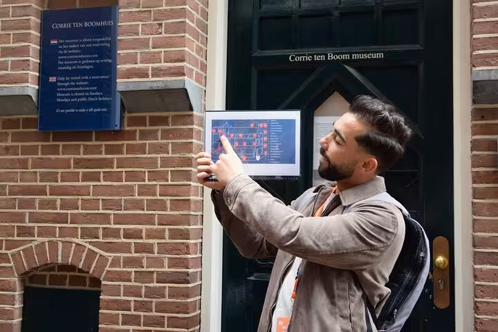 Guide explains Corrie ten Boom museum entrance during Haarlem WW2 experience tour with map display