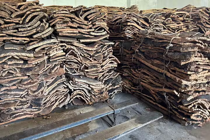 Stacks of raw cork bark are seen at the Cortiza and Herdade Alentejo Factory, showcasing traditional processing.