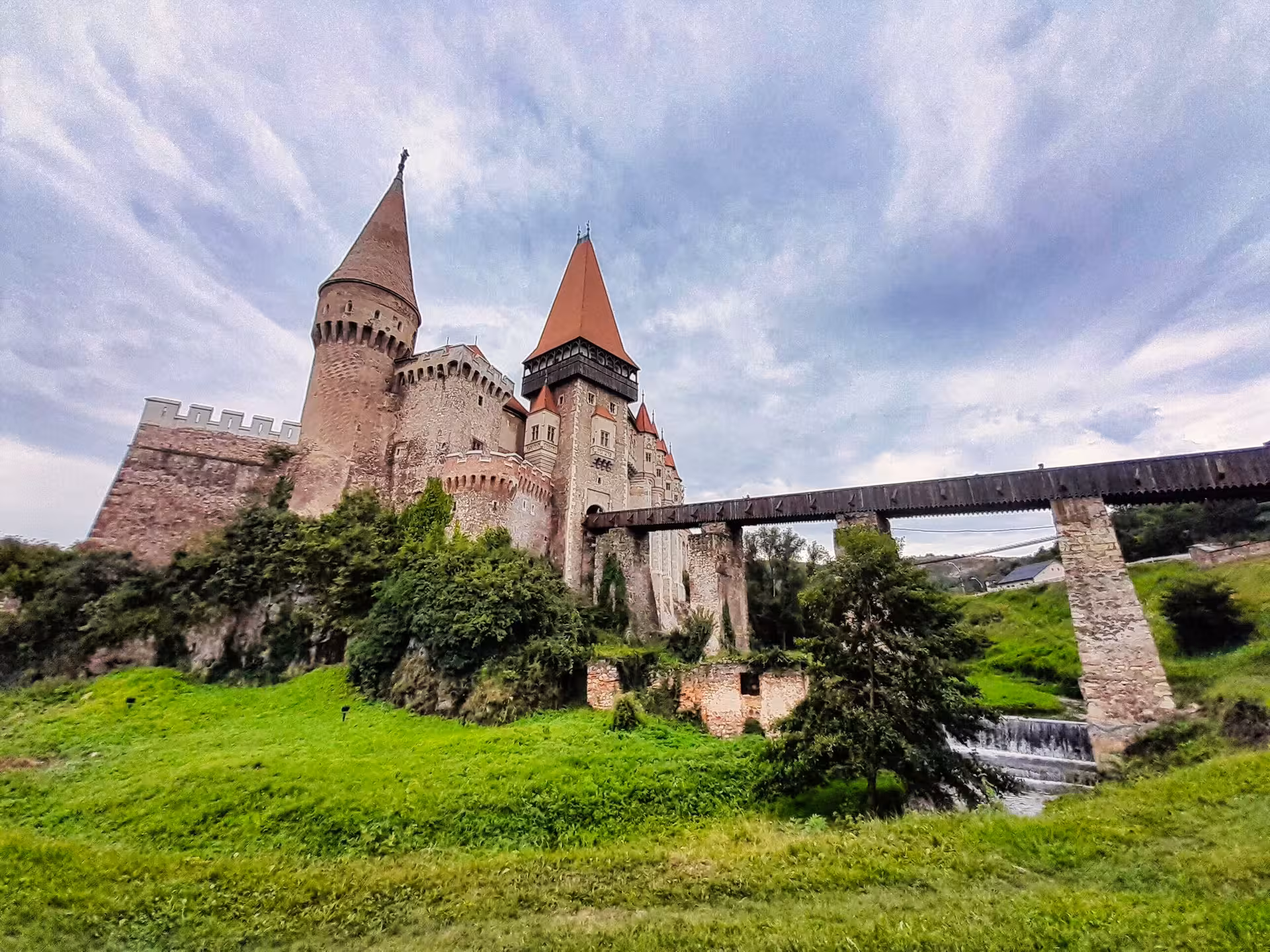 Stunning exterior view of Corvin Castle with medieval towers and wooden bridge on a guided tour from Cluj