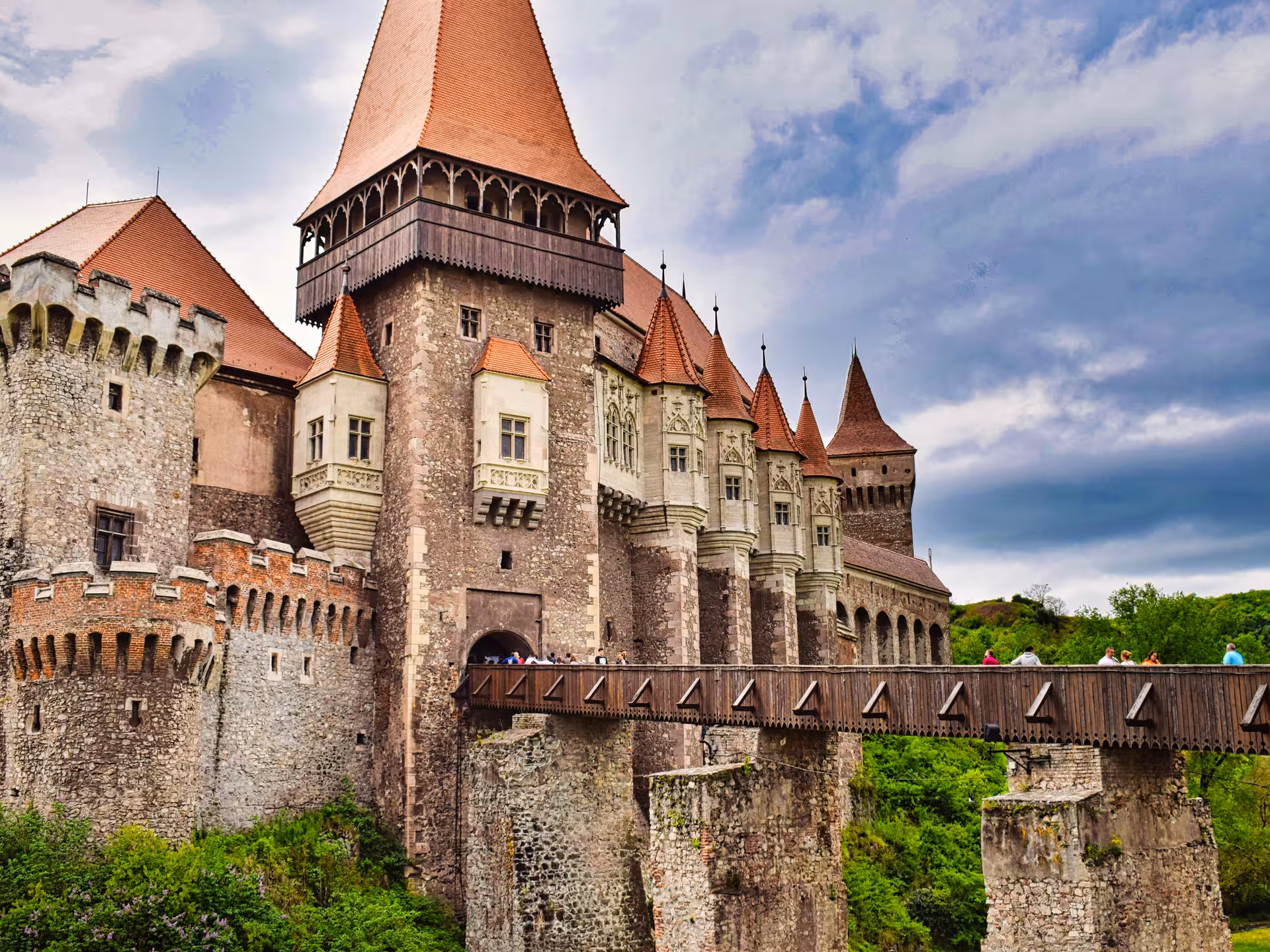 Majestic Corvin Castle with red-roofed towers and wooden bridge on Best of Transylvania guided tour