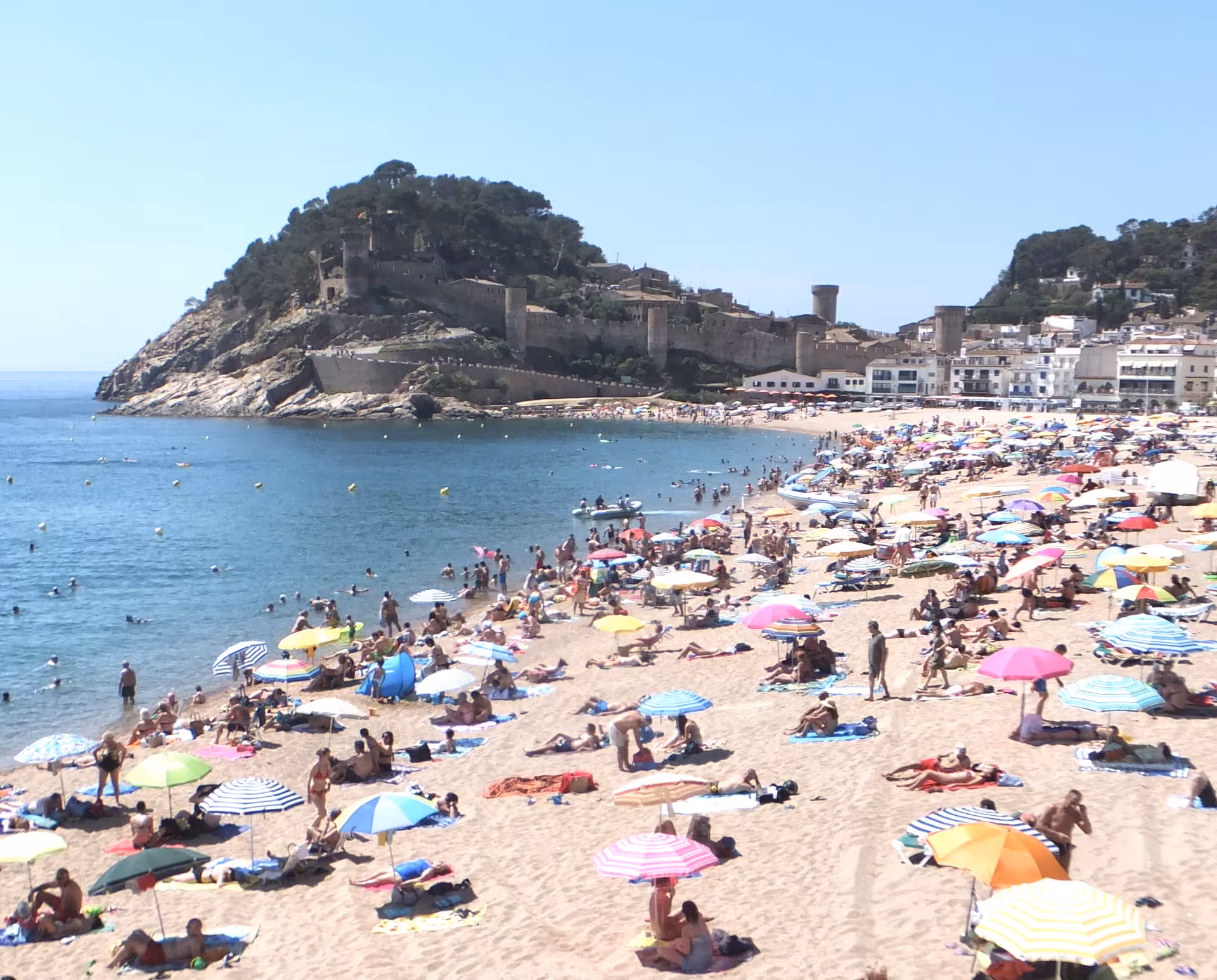 Sunny Costa Brava beach near Tossa de Mar castle, popular Barcelona day trip with swimming and sunbathing