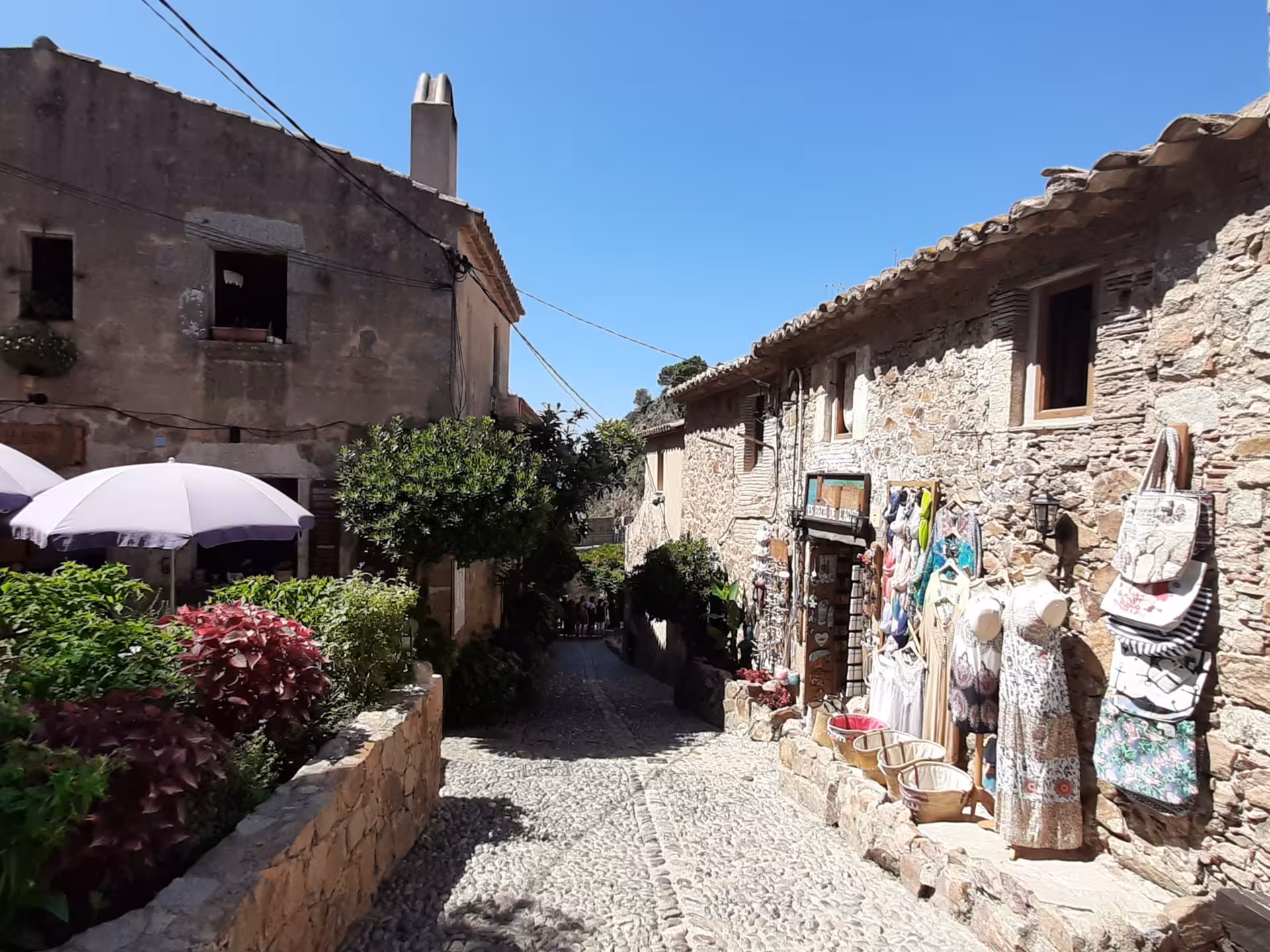Cobblestone street in Costa Brava village on day trip from Barcelona, stone houses and local shops