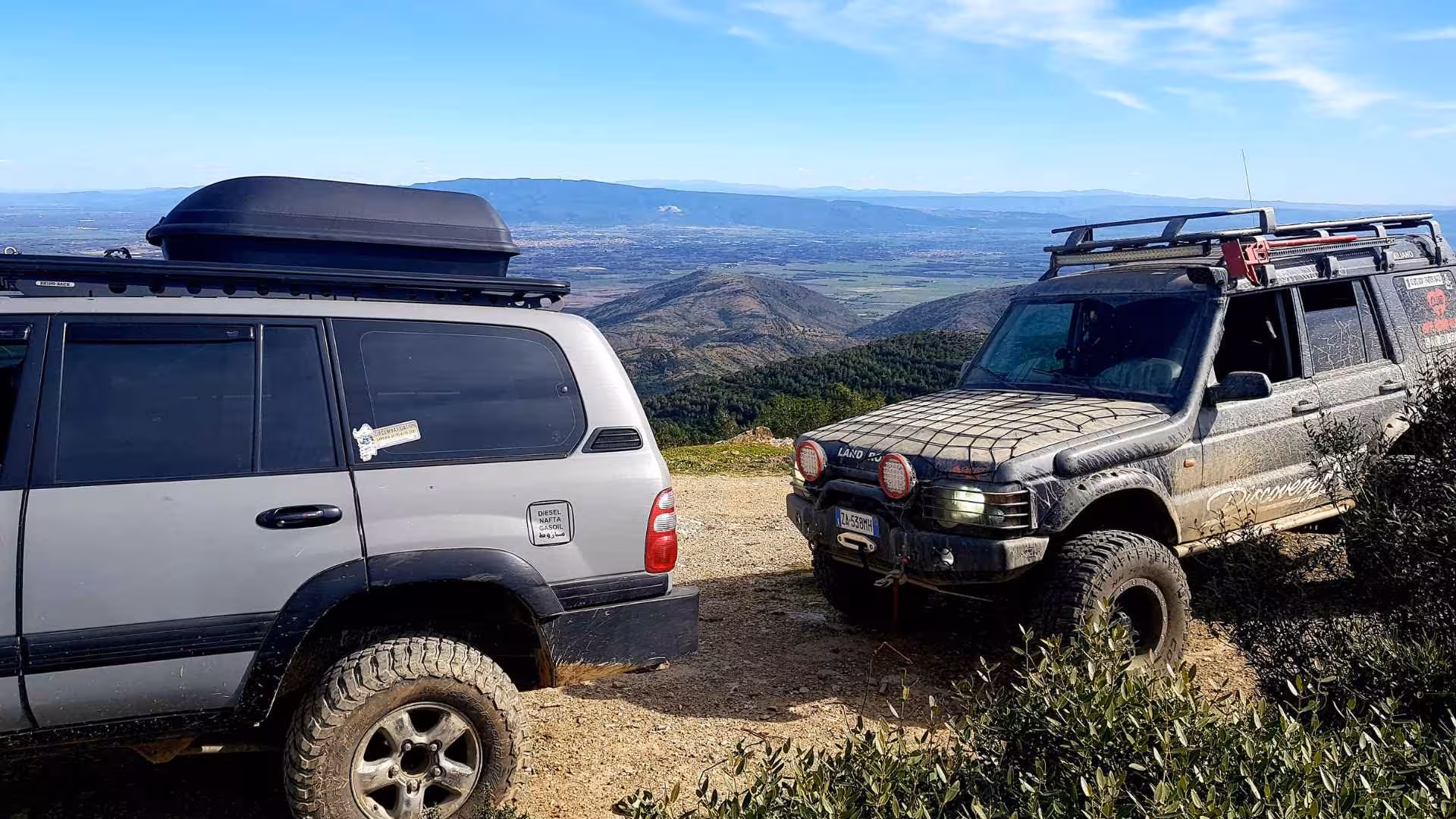 Off-road vehicles parked on a scenic hill during a Costa Verde adventure tour from Oristano.