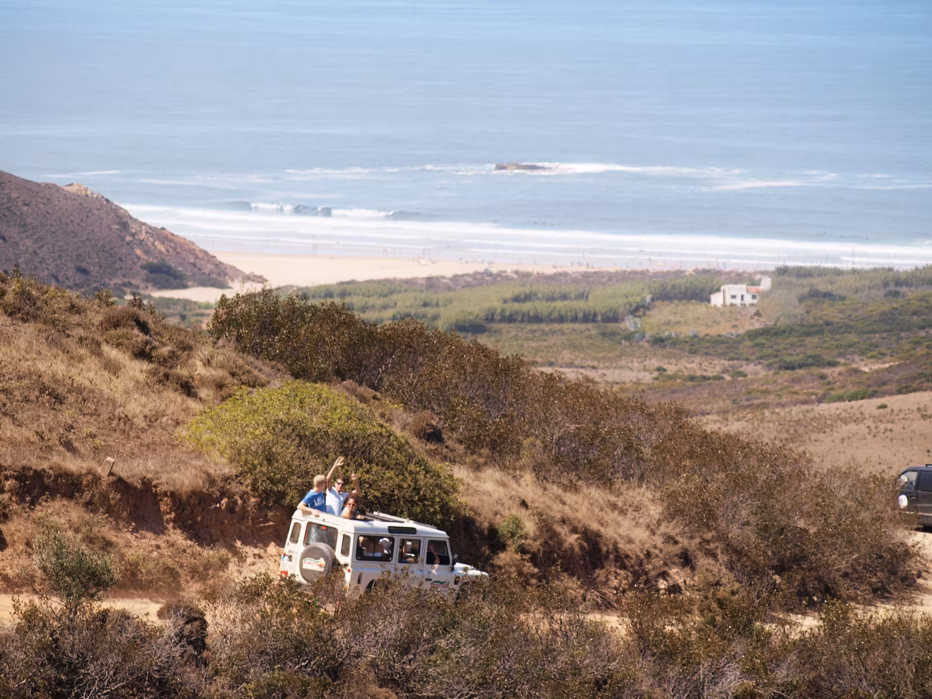 Off-road 4x4 tour winding through Costa Vicentina cliffs with sweeping views of wild beach and Atlantic Ocean