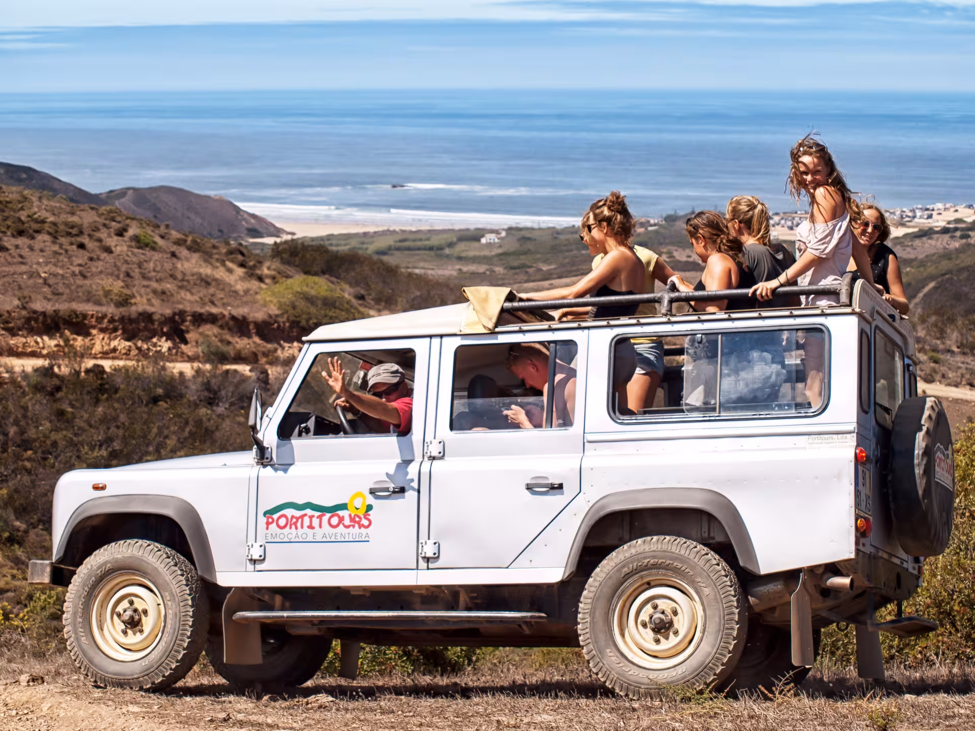 Group enjoying Costa Vicentina wild coast jeep safari, driving cliffside tracks above the Atlantic Ocean in southwest Portugal