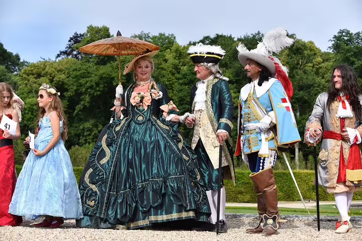 Costumed reenactors in palace gardens on a private Fontainebleau and Vaux-le-Vicomte day tour from Paris