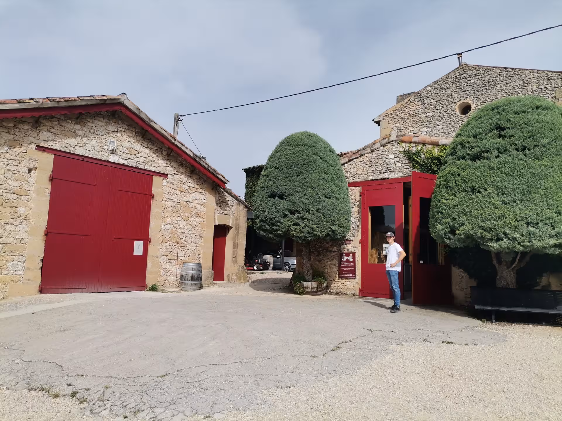 Traditional Provence winery with stone buildings and red doors, stop on Coteaux d'Aix Sainte-Victoire vineyard tour