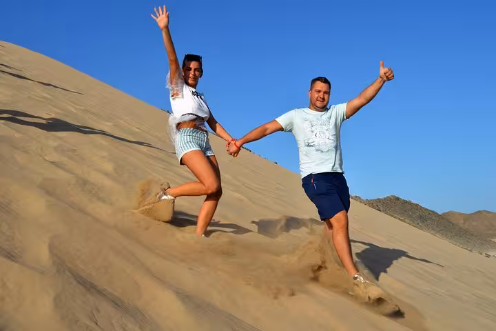 Couple running down sandy dunes in Sharm El Sheikh, fun stop during sunrise or sunset ATV quad safari tour