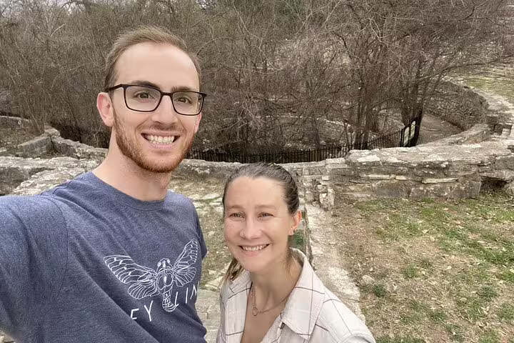 Couple smiling at outdoor stone ruins during self-guided walking tour in Austin