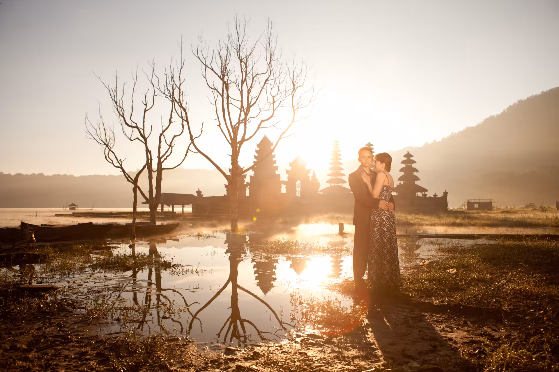 Couple embracing near Bali's iconic temple at sunset, capturing romance and cultural backdrop in a private photoshoot.