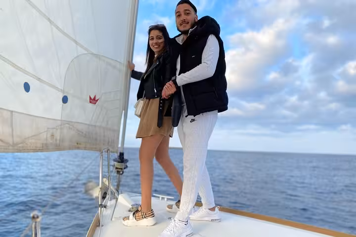 Couple posing on deck during a 2-hour Barcelona sailing tour, enjoying sea views with open bar and snacks