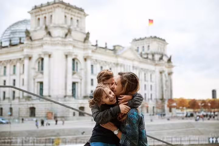 Couple hugging by Berlin Reichstag building during a personal travel photographer tour and vacation photo shoot