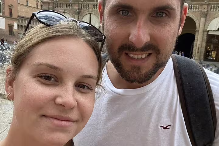 Couple smiling during self-guided walking tour in Bologna Old Town piazza
