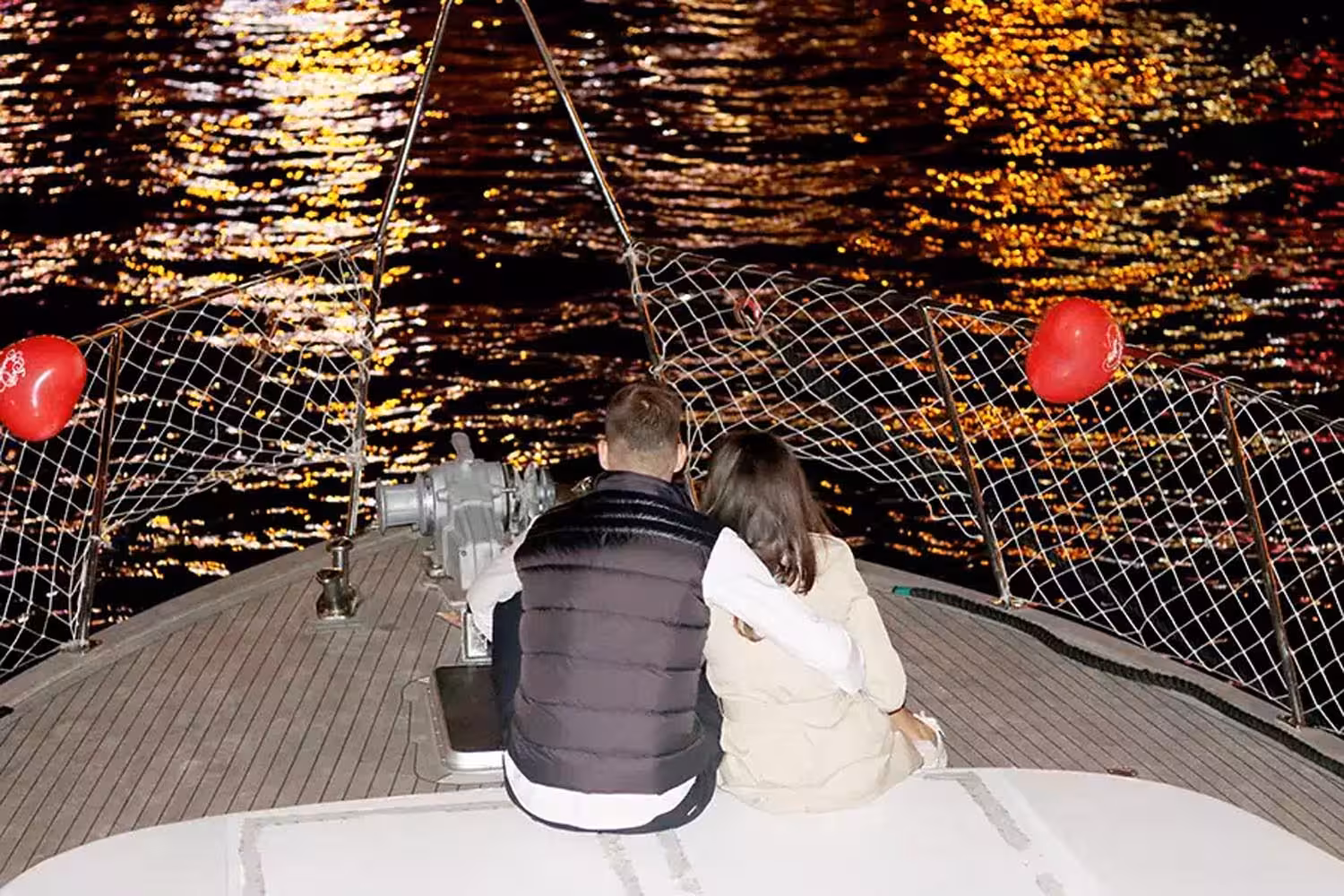 Couple cuddling on the bow during a private Bosphorus night cruise, perfect romantic marriage proposal experience