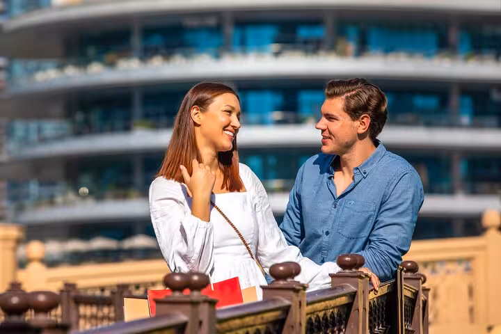 Couple sharing a moment on a bridge, surrounded by stunning architecture on the Burj Khalifa Instagram tour.