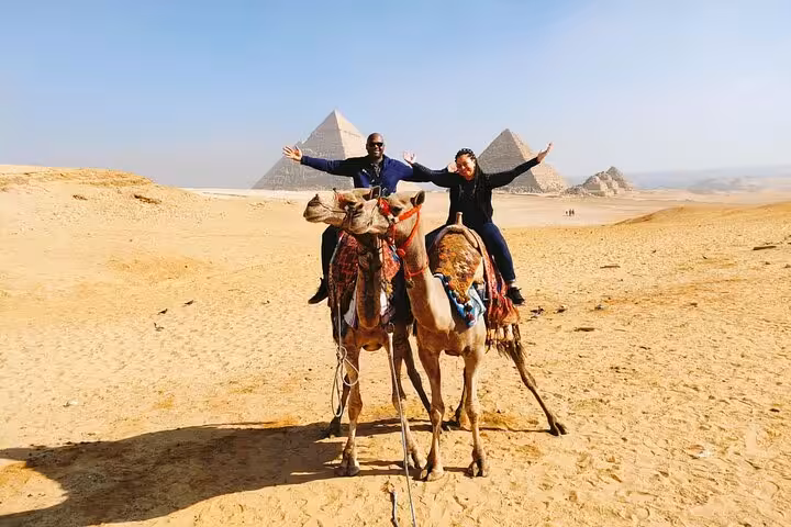 Couple posing on camel ride with Giza Pyramids view, Cairo desert tour with lunch, quad bike and shopping