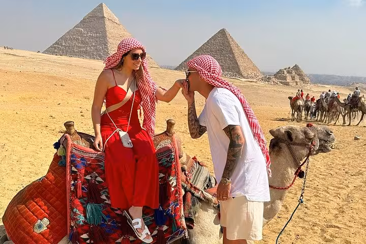 Couple on camel at Giza Pyramids, Cairo desert, enjoying camel ride tour with lunch and photo stop