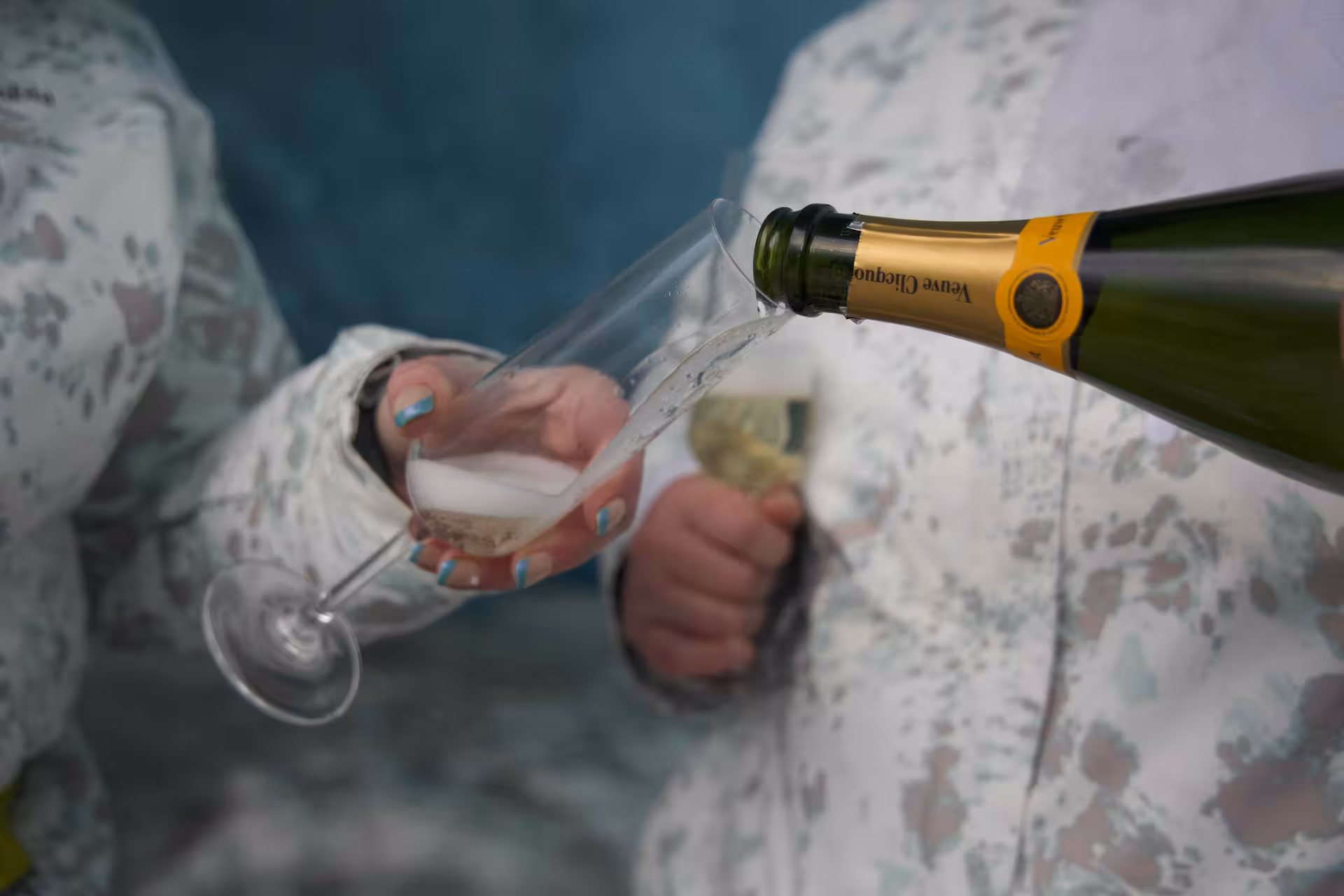 Couple celebrating with Veuve Clicquot champagne during a romantic Iceland sunrise proposal tour near Glacier Lagoon.