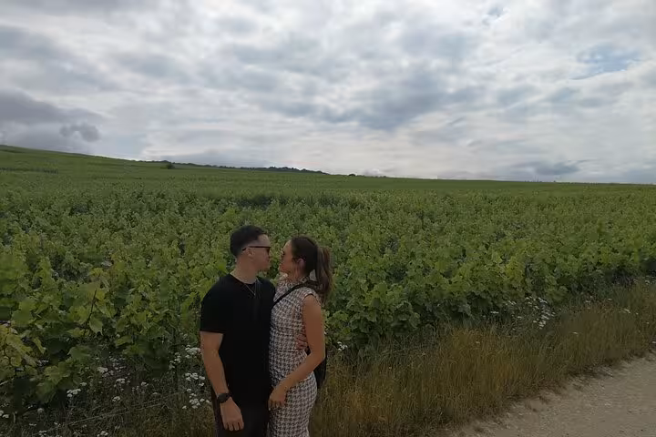 Couple sharing a romantic moment in the lush Champagne vineyards near Reims, France