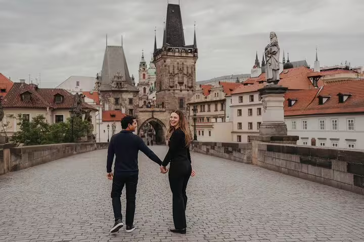 Happy couple embracing by the iconic Charles Bridge in Prague during a professional photoshoot session.