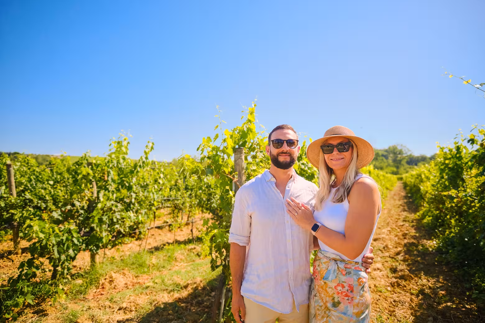 Couple enjoying a sunny day in a Chianti vineyard during a private half-day tour from Florence.