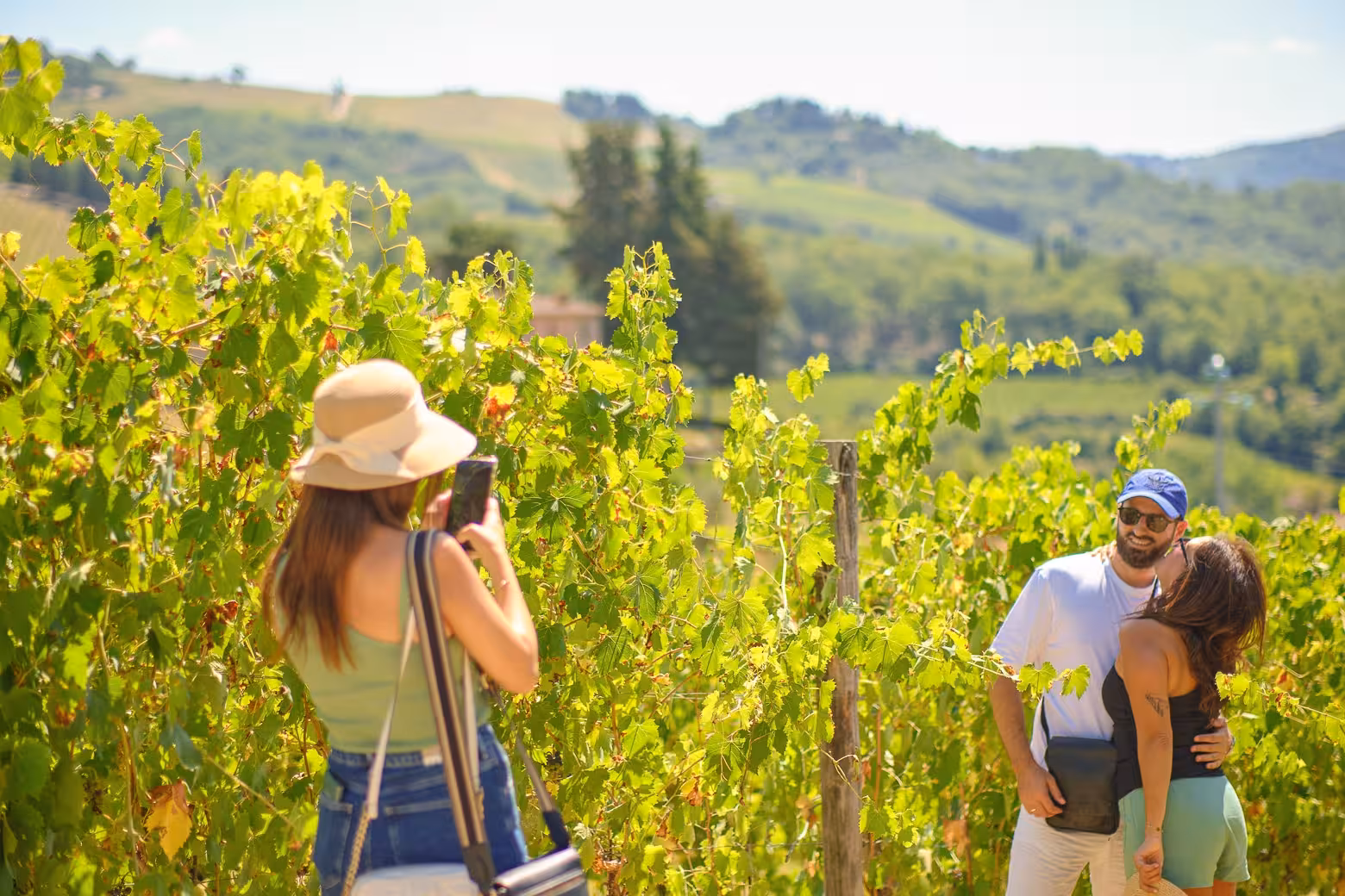 Couple posing for a photo in lush Chianti vineyards during a Florence wine tasting tour.