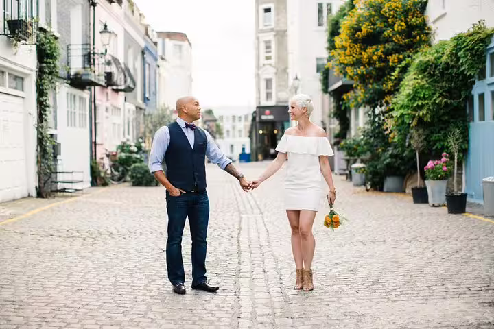 Couple holding hands on a charming cobblestone street in London, perfect for a personal travel photography tour.