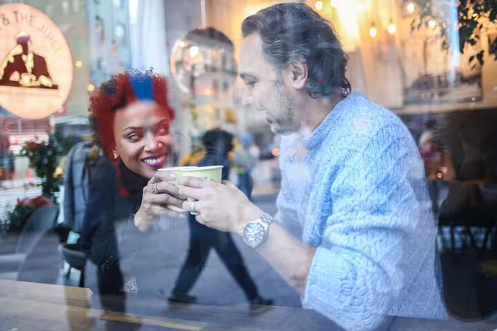 Couple sharing coffee through café window in Brooklyn, candid moment on a personal NYC photography tour