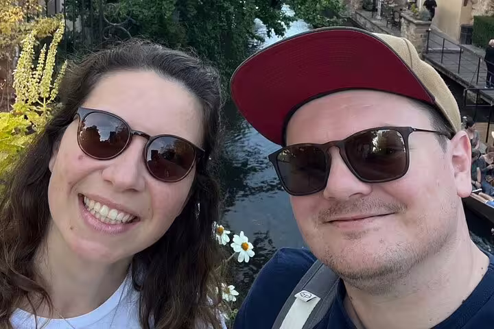 Couple selfie by Colmar canal on a self-guided scavenger hunt tour, exploring Little Venice sights