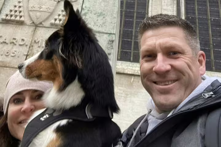 Couple with Bernese Mountain Dog on Brussels self-guided walking tour near historic stone building