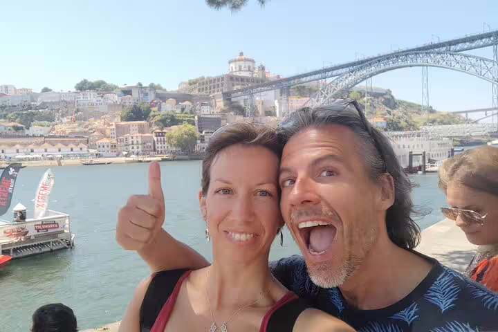 Couple selfie with thumbs up by Dom Luís I Bridge and Douro River, Porto self-guided scavenger hunt tour