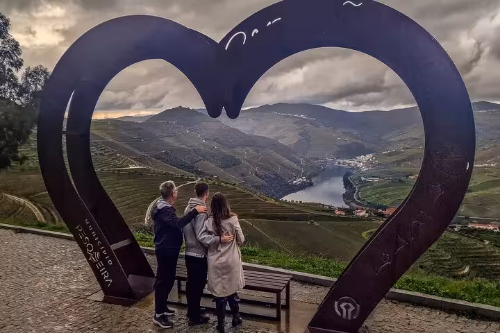 Couple at Douro Valley heart viewpoint overlooking river, private Porto to Lisbon transfer with wine boat brunch