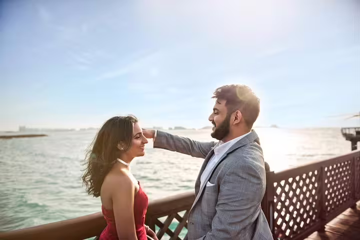 Couple posing on Dubai waterfront boardwalk at sunset during a private travel photographer tour session
