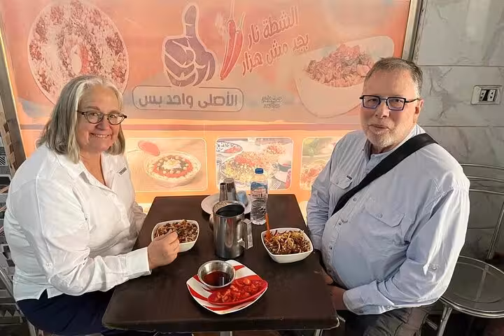 Couple eating koshary lunch in Cairo, part of Khan el Khalili Market shopping and local food tour