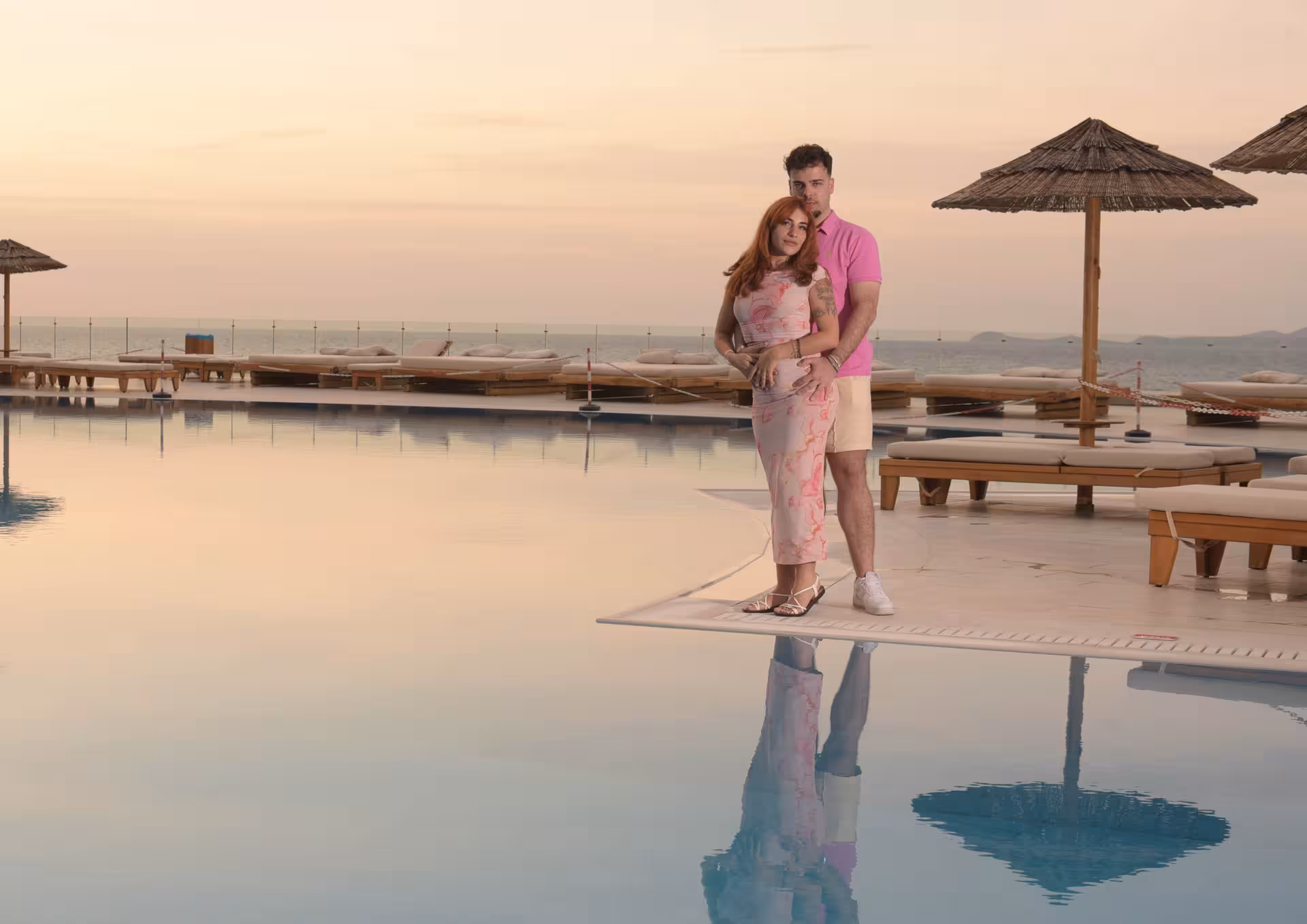 Couple embraces by the pool at sunset in Heraklion Venetian Port, ideal for a romantic photoshoot experience.