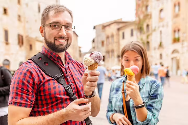 Couple enjoys gelato in a vibrant Italian market during The Vatican Market Experience, featuring tastings and a cooking class.
