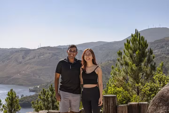 Couple enjoying a sunny day with stunning views of Geres National Park's lush landscape and blue lagoons.