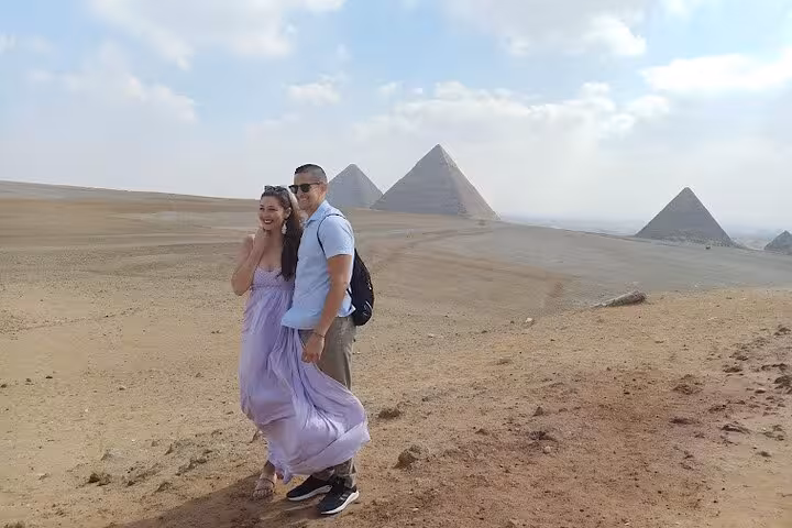 Couple posing at Giza Pyramids desert viewpoint on Cairo day tour to Grand Egyptian Museum and lunch included