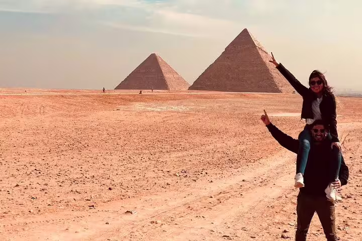 Couple celebrating at the Giza Pyramids desert viewpoint on a 2-day Port Said to Cairo and Giza guided tour