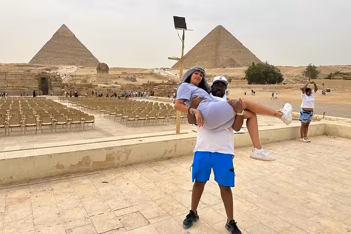Couple posing at Giza Pyramids viewpoint during 4-day private Cairo tour, Great Pyramid in background