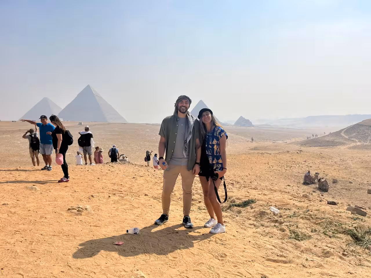 Couple posing near Giza Pyramids on Cairo desert tour with camel ride experience and lunch included