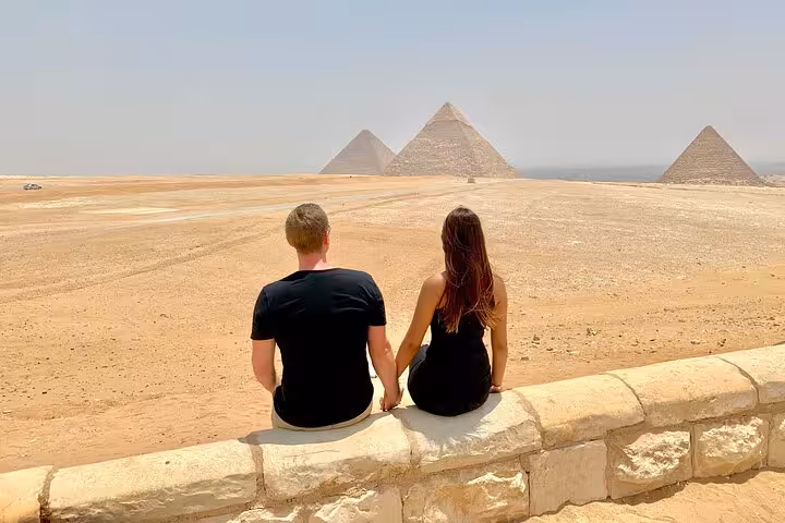 Couple overlooking Giza Pyramids desert panorama on private Cairo tour to Giza, Saqqara and Memphis with camel ride