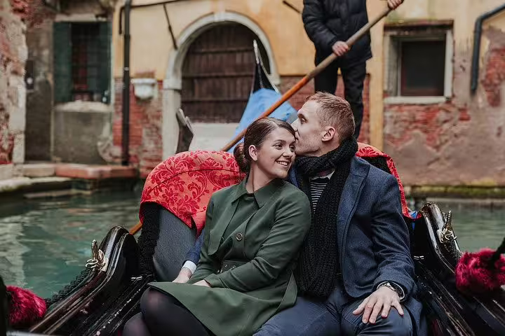 Couple enjoying a cozy gondola ride through the charming canals of Venice, capturing intimate moments together.