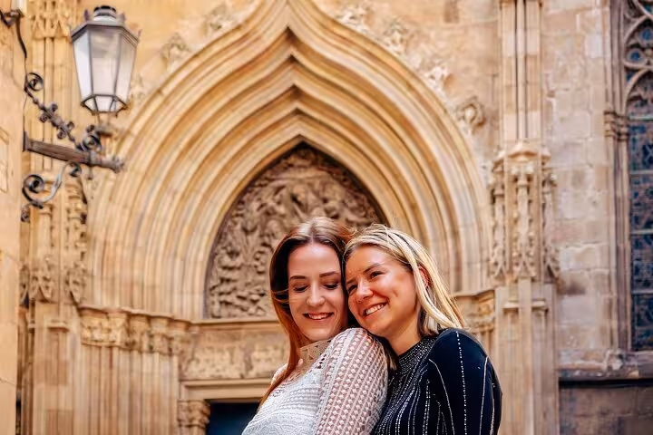 Happy couple posing under a Gothic arch in Barcelona’s Gothic Quarter, perfect for a romantic old-town photoshoot.