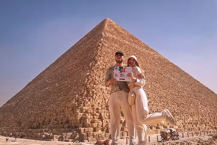Couple posing at the Great Pyramid of Giza on a Cairo full-day customized tour with free camel ride