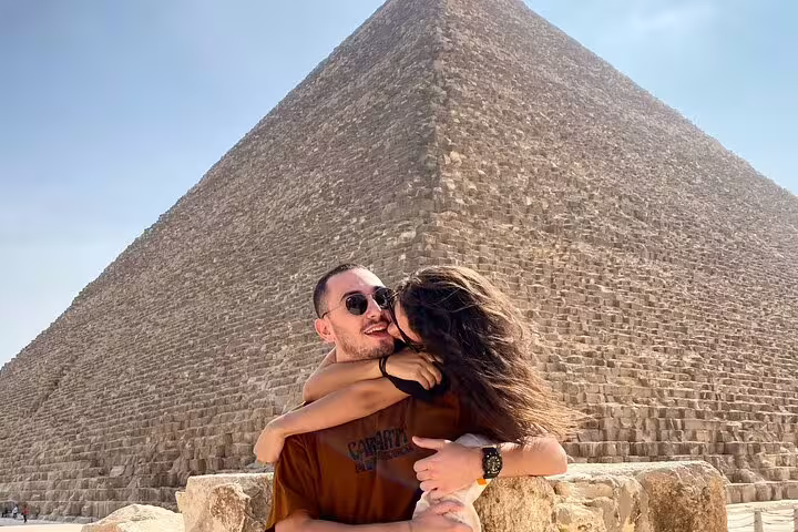 Couple posing at the Great Pyramid of Giza on Port Said to Cairo pyramids and bazaar tour