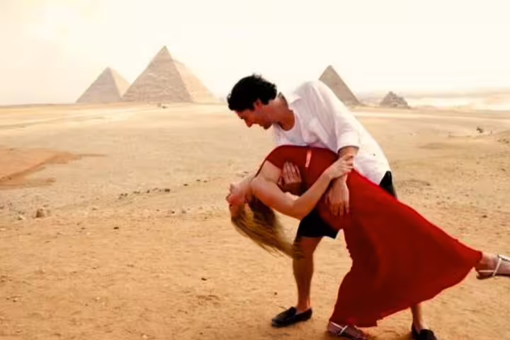 Couple posing in Giza desert with Great Pyramids backdrop on Cairo day trip from Port Said 2-day tour