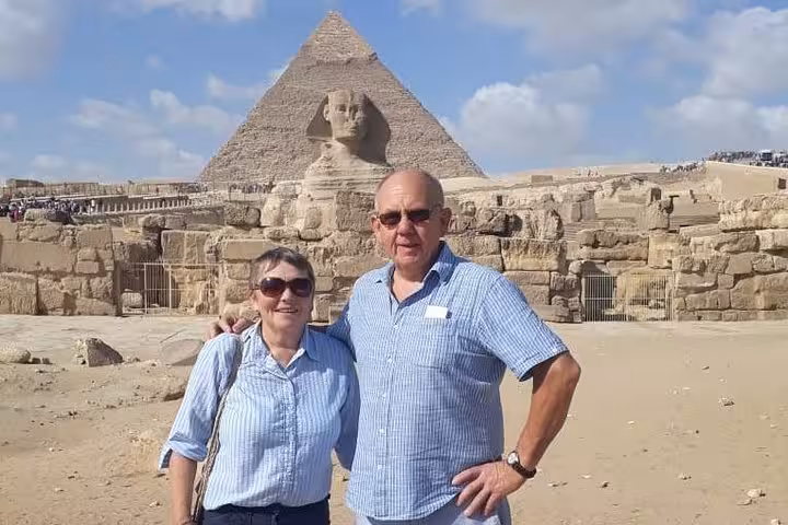 Couple posing by Great Sphinx with Giza Pyramid behind on private full-day Cairo tour with Egyptian Museum visit