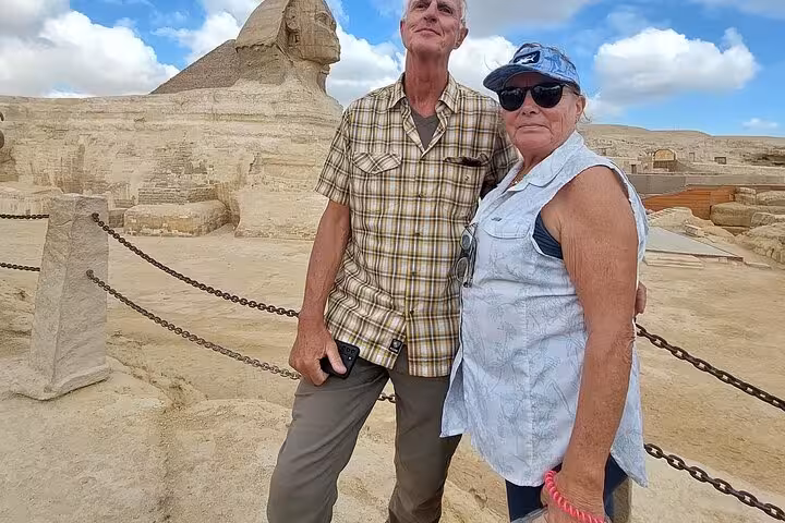 Couple posing by the Great Sphinx at Giza on a Cairo private tour, pyramids plateau sightseeing stop